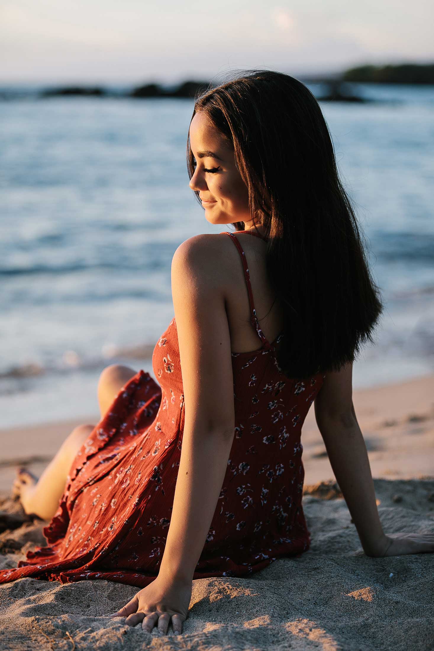image of a senior portrait of a girl looking at the surf near the beach