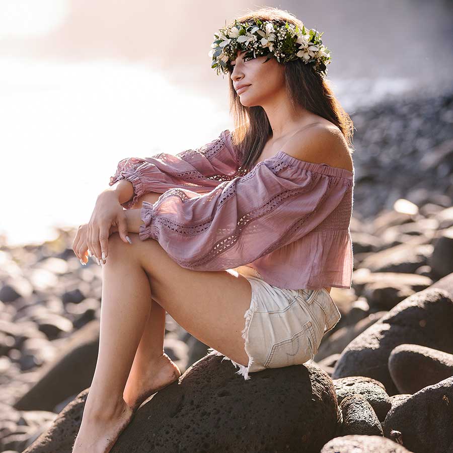 image of a senior portrait of a girl on the rocks near the beach