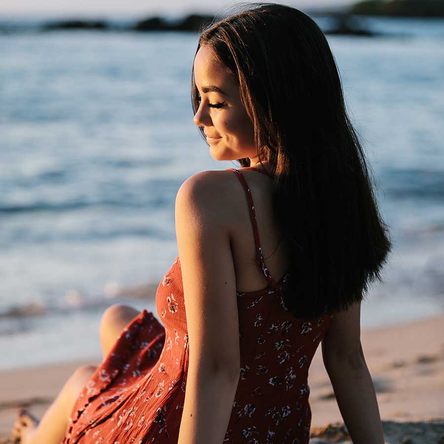 image of a senior portrait of a girl looking at the surf near the beach
